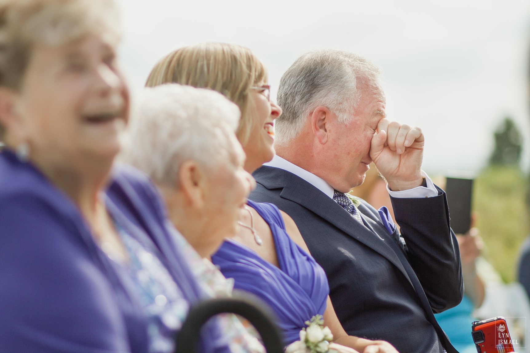 Groom's father wipes his tears away