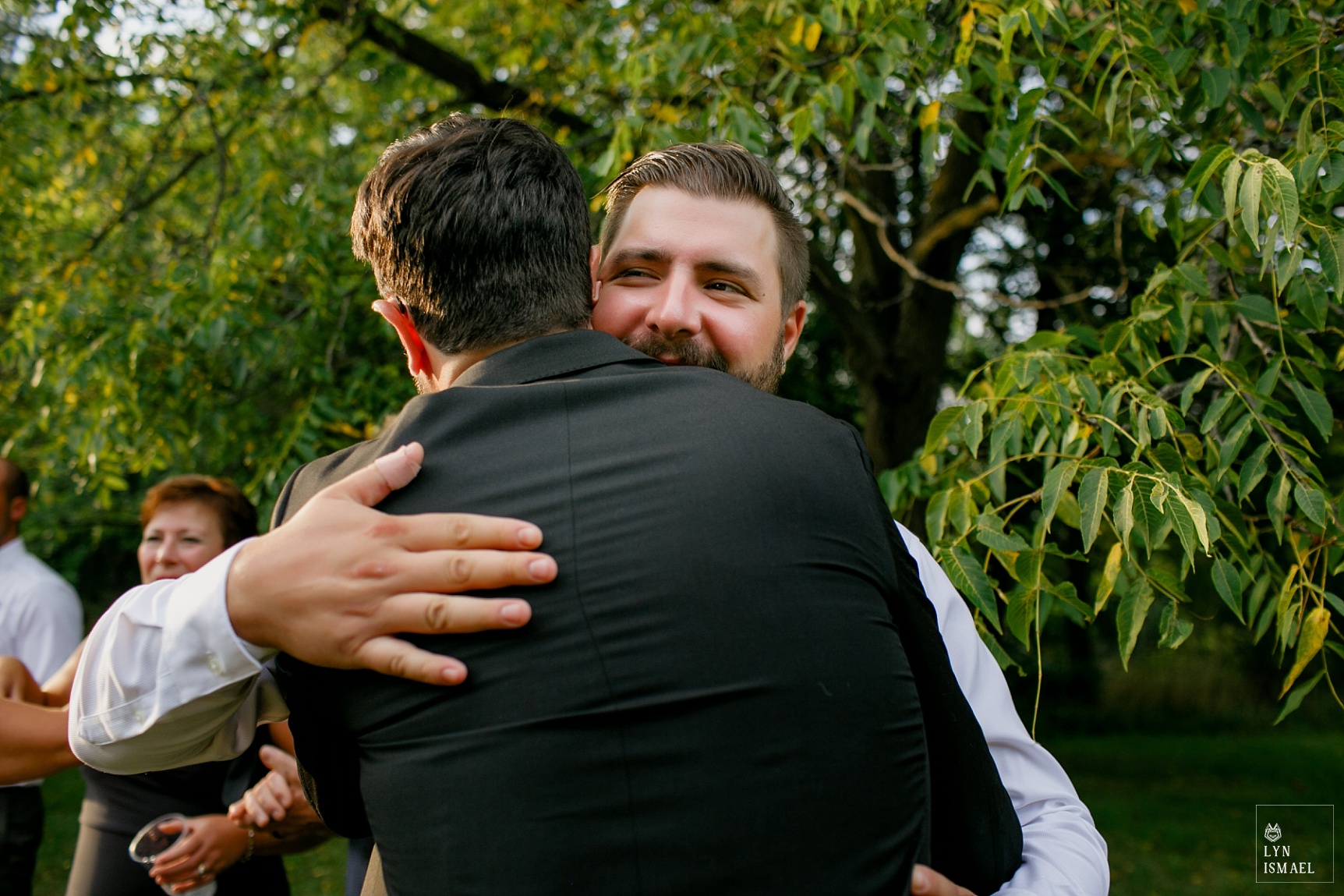 Groom hugs one of his guests as they greet each other at Steckle Heritage Farm