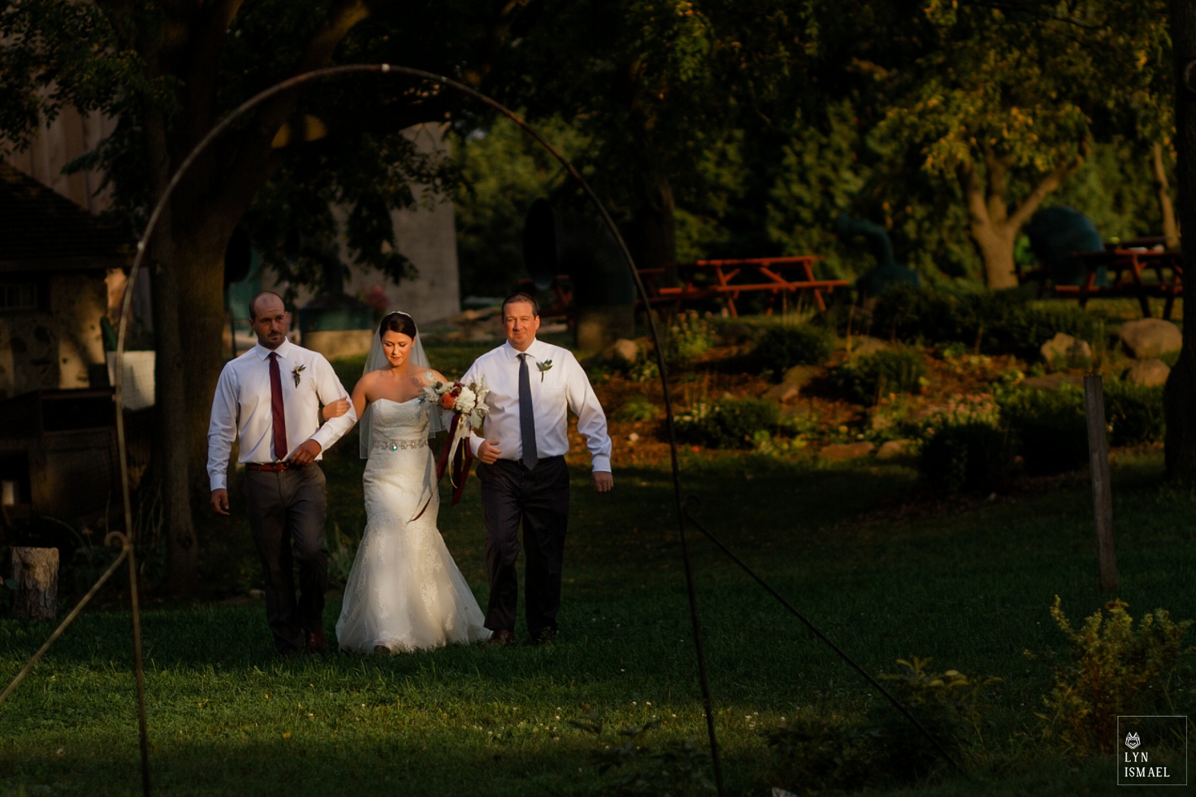 Bride walks down the aisle with her father and brother at her wedding at Steckle Heritage Farm