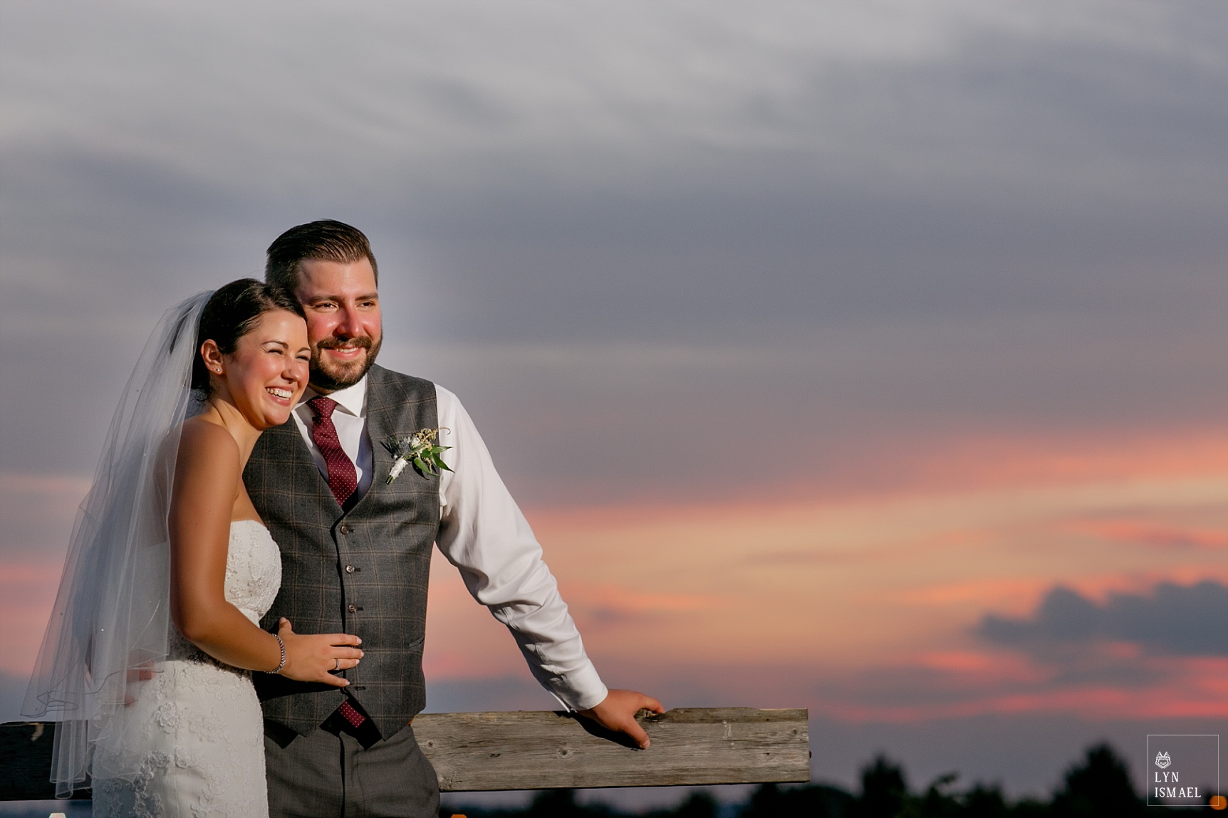 Bride and groom poses at sunset