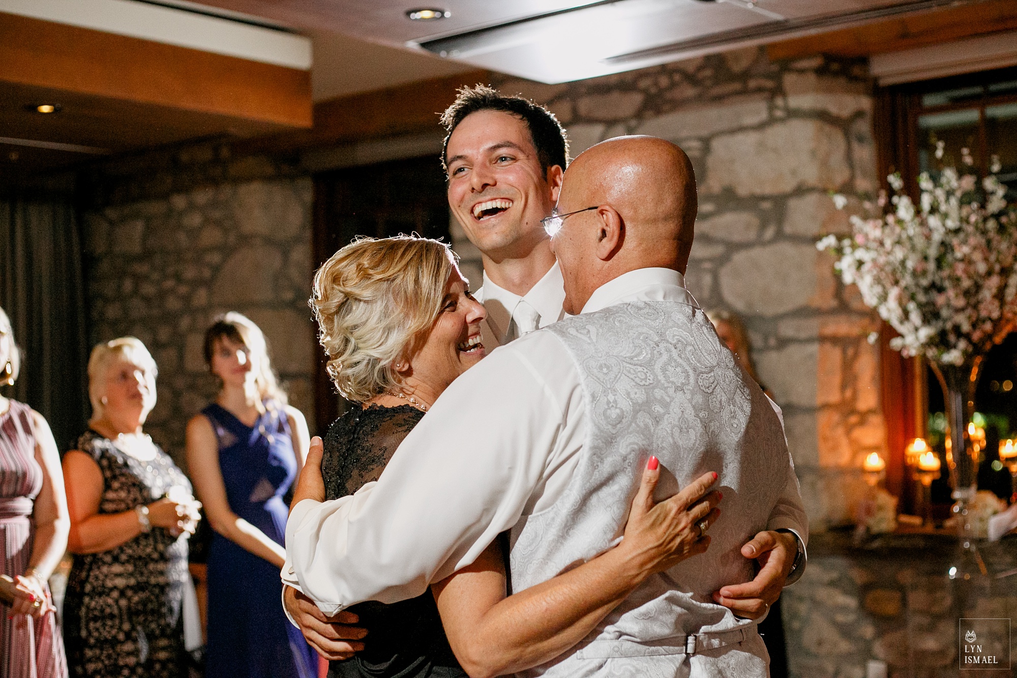 Groom and his parents group hug