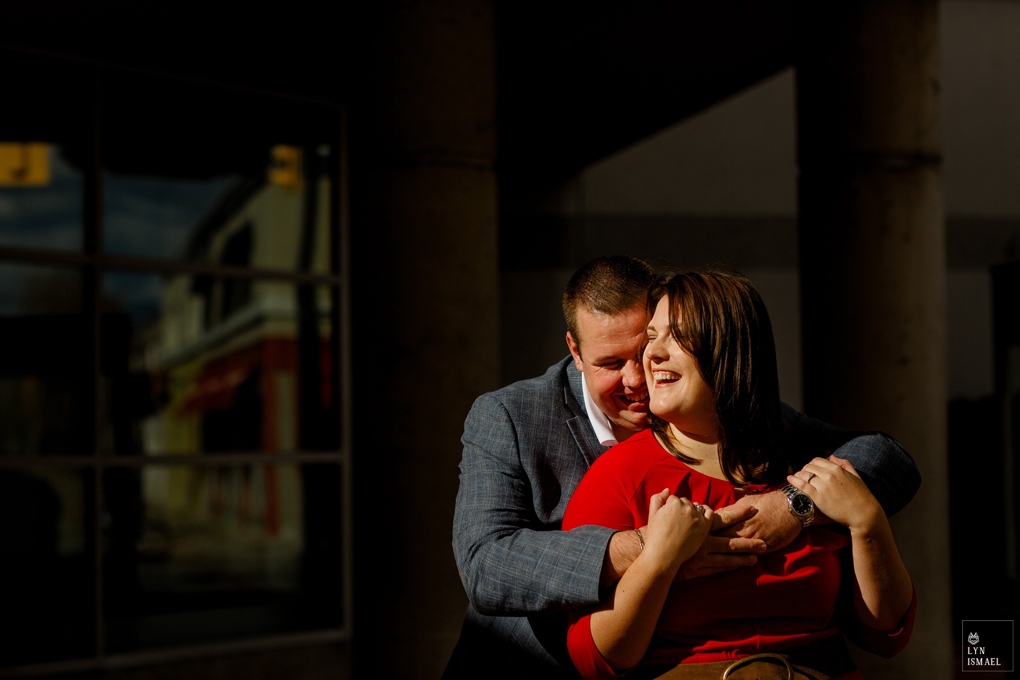 A couple stands in front of the Burlington city hall for their engagement session 
