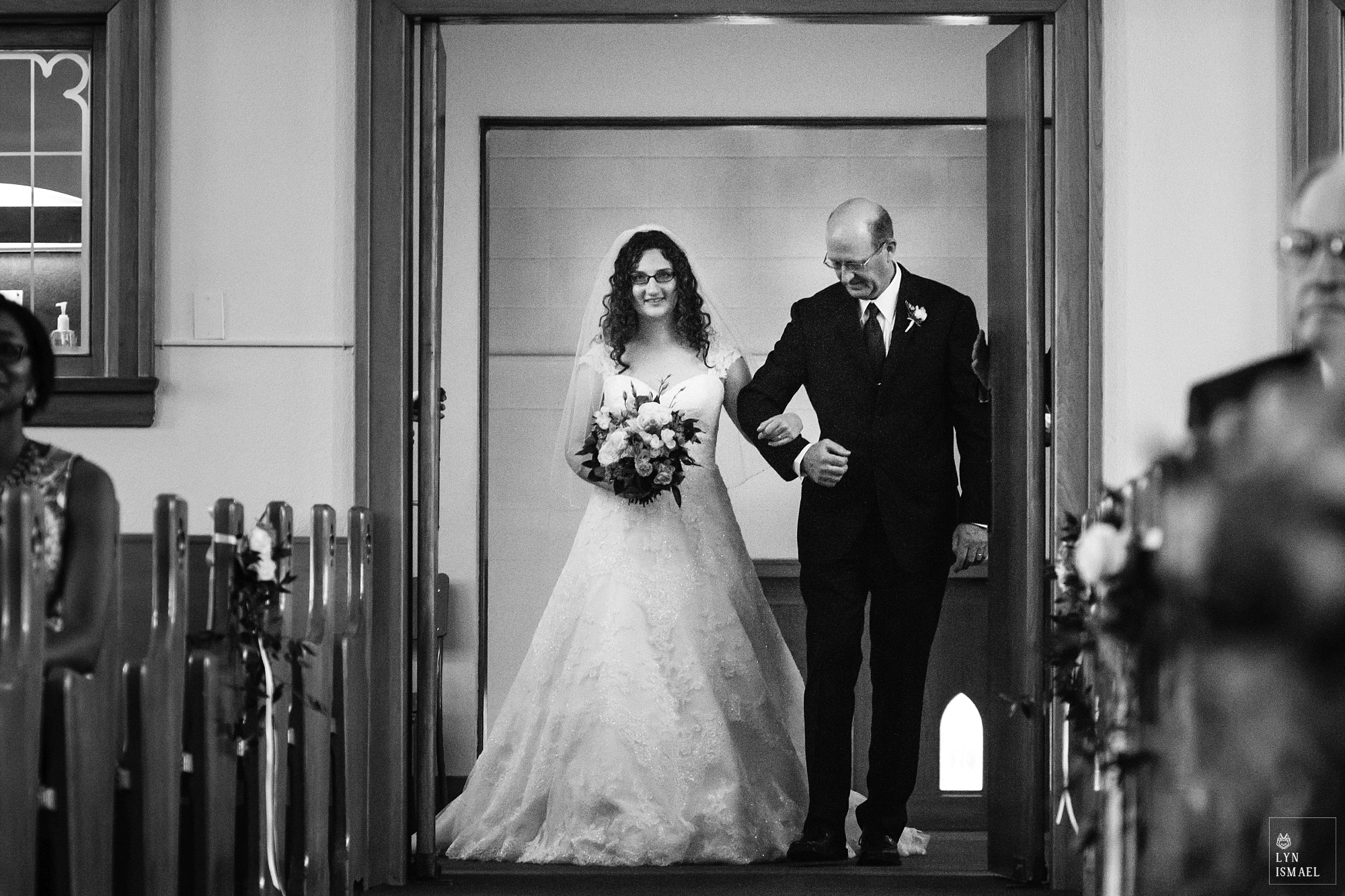 Bride walks down the aisle with her father at the Kitchener Mennonite Brethren Church