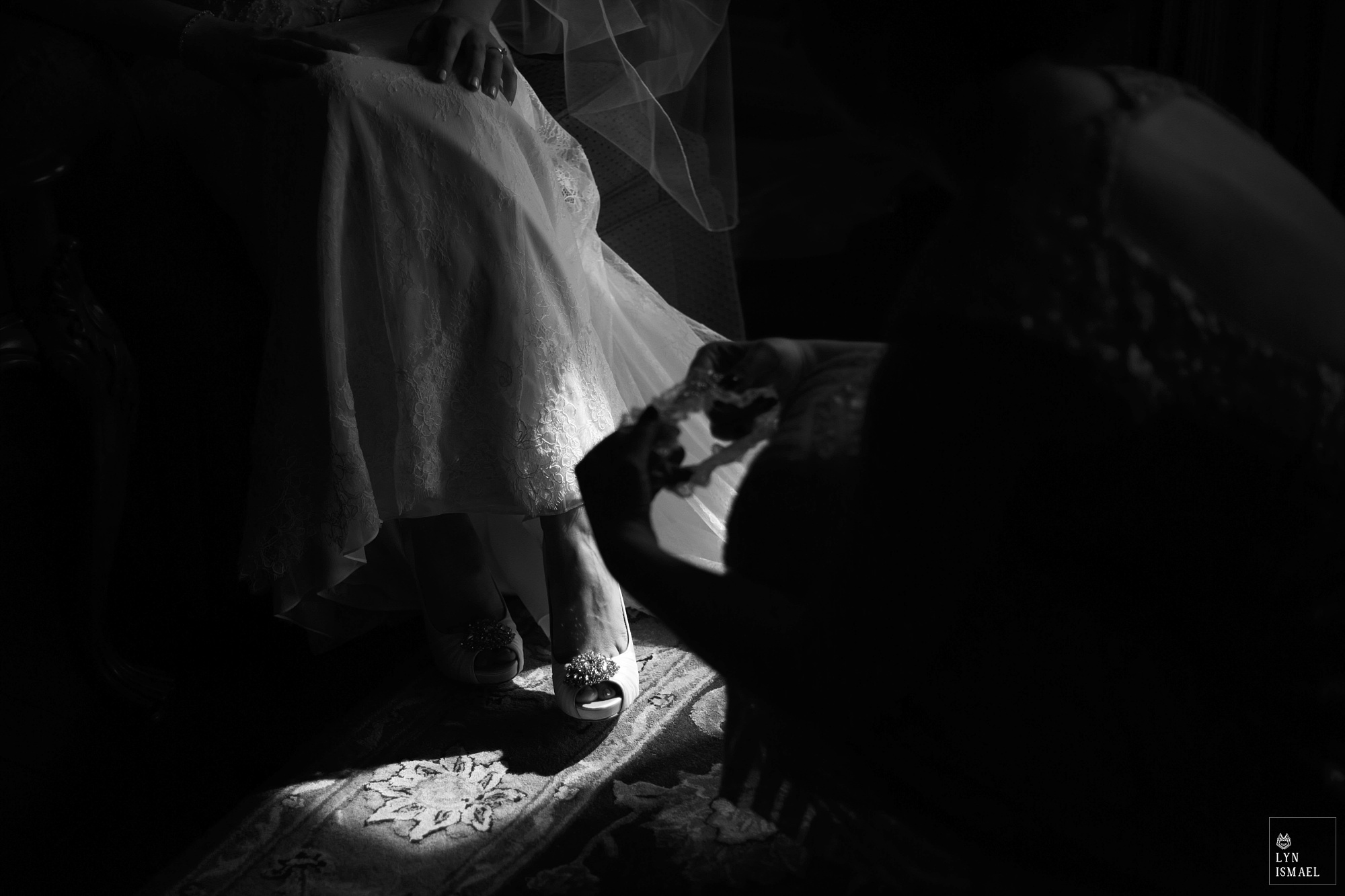 Bride puts on her shoes in the sunlight.