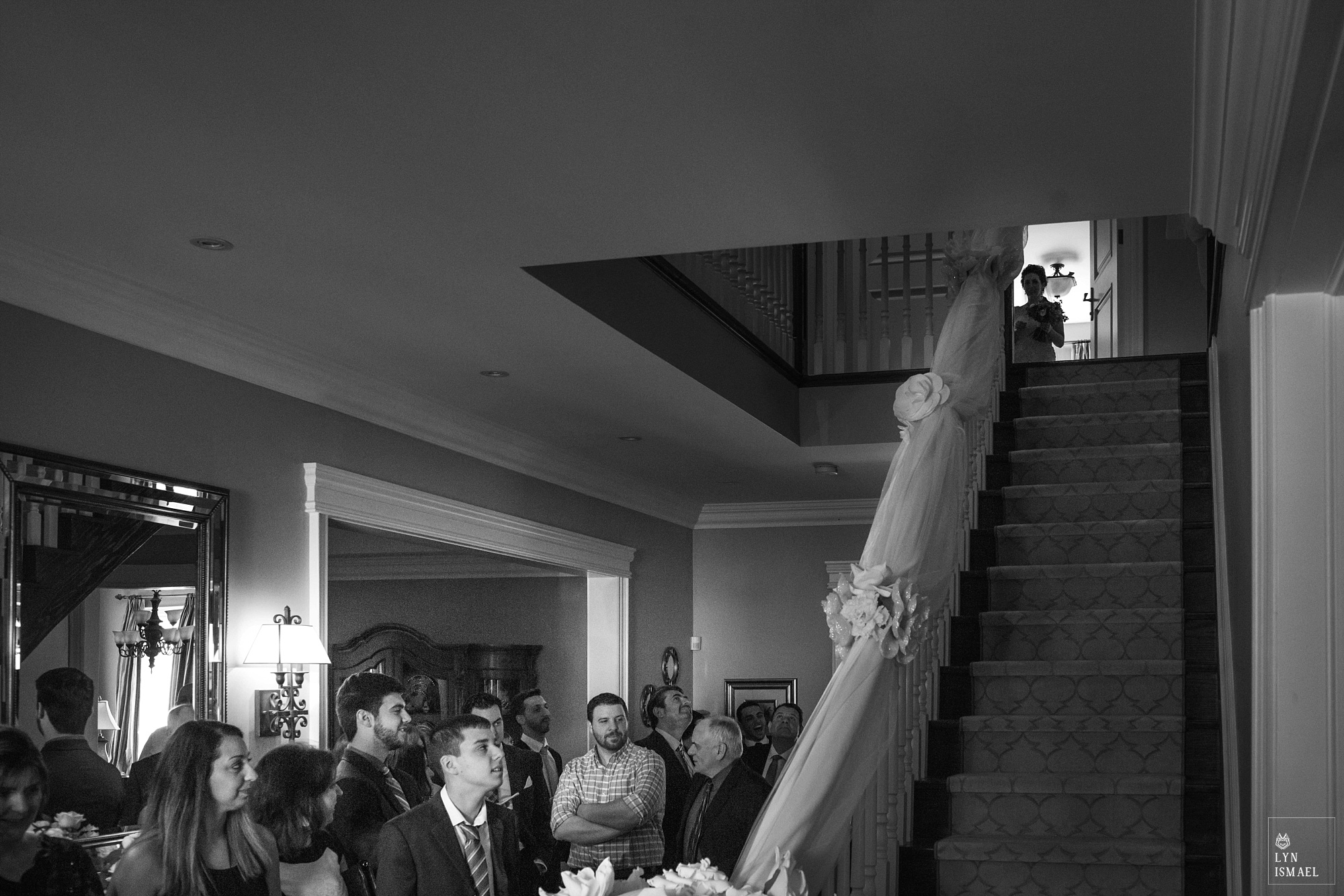 Bride's family awaits for the bride to come down the stairs