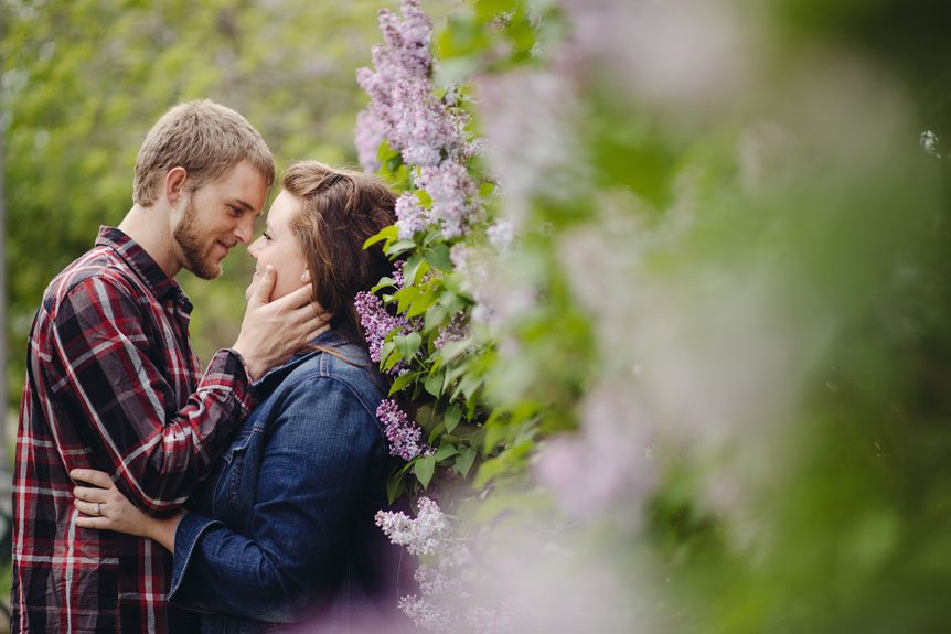 Beautiful engagement session surrounded by lilac blossoms.