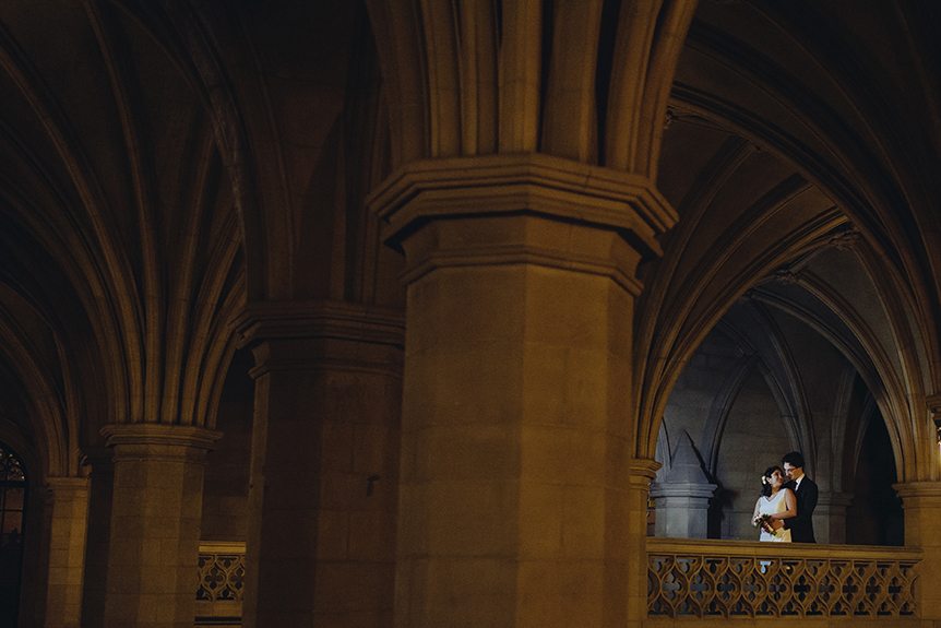 A dramatically lit portrait of the bride and groom inside Knox College.