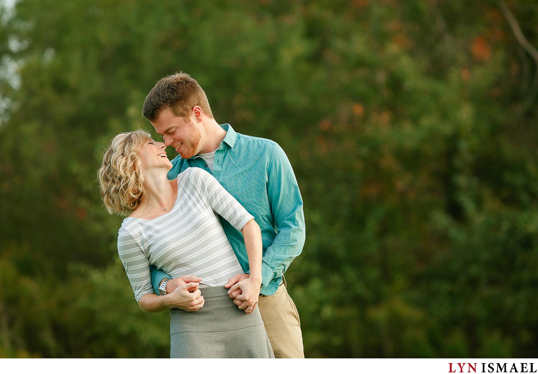 A wedding photographer photographs a couple's engagement session in Kitchener's Huron Natural Area.