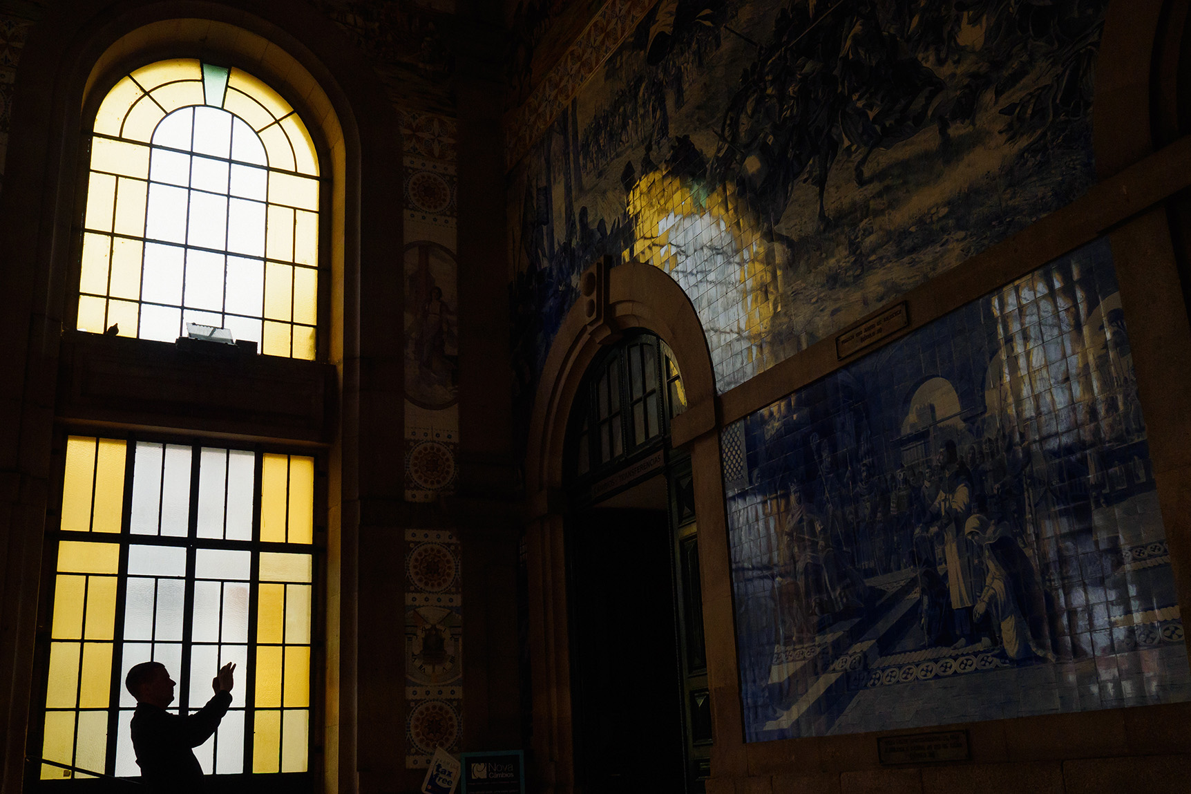 Silhouette of a man taking a photograph at the Sao Bento train station in Porto